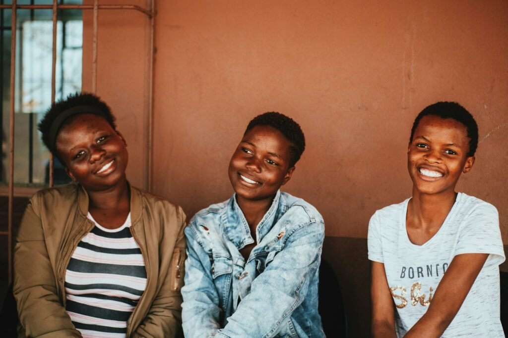Trois jeunes femmes souriantes assises côte à côte